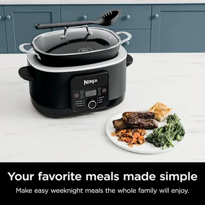 Communicates that the Ninja cooker simplifies meal preparation for busy families, showing the product in a lifestyle setting with a finished meal to demonstrate convenience and results.