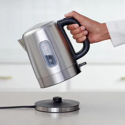 Shows the kettle being used in a real kitchen setting to help shoppers visualize the product in their own home and understand its ergonomic design.