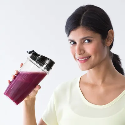 Demonstrates the product being used in a real-world setting to help shoppers visualize themselves using the blender bottle for healthy smoothies or beverages.