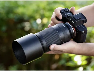 Demonstrates the product in a real-world outdoor photography context to help shoppers visualize themselves using the camera and lens system.