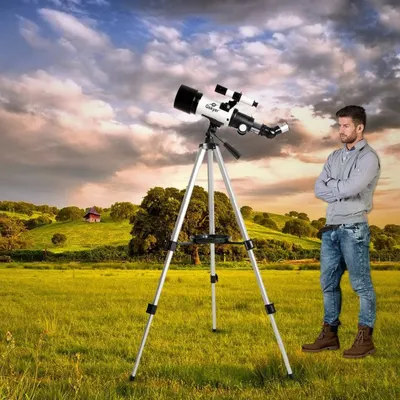 Shows the telescope in a real-world outdoor setting to help shoppers visualize using the product for astronomy and nature observation.