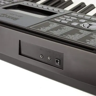 Highlights the physical connectivity features of the keyboard, showing the microphone input, headphone output, and power connection ports to inform shoppers about available connection options.