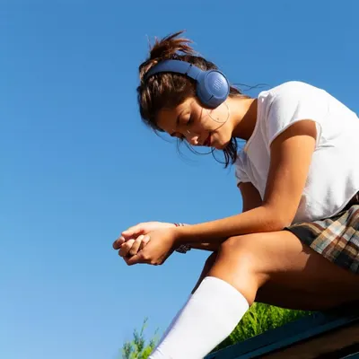 Demonstrates the product being used in a real-world outdoor athletic context to help shoppers visualize themselves using the headphones during active lifestyle moments.