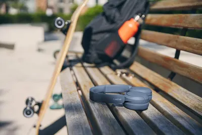 Demonstrates the product in a real-world outdoor lifestyle context, showing its portability and suitability for active, on-the-go use with skateboarding gear.