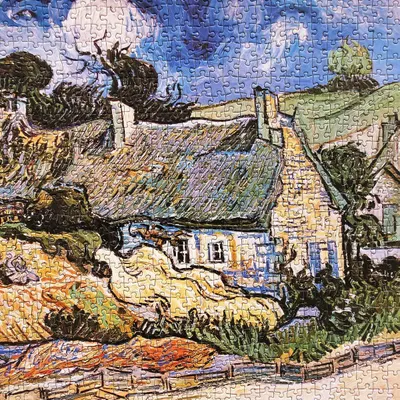 This image shows a completed jigsaw puzzle depicting a cottage with trees and landscape. It appears to be a product display showing the finished puzzle result.