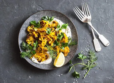 Showcases the product (likely roasted cauliflower or similar food item) in an appetizing, real-world dining context to help shoppers visualize the final result and appeal.