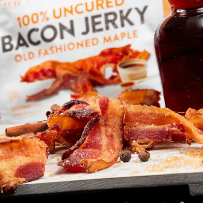 Highlights the product's natural, uncured preparation and distinctive old fashioned maple flavor to appeal to health-conscious consumers seeking premium, authentic bacon jerky.