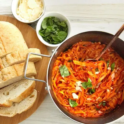 Showcases the product (pasta dish) in an authentic, appetizing real-world setting to help shoppers visualize the meal experience and inspire purchase through lifestyle appeal.