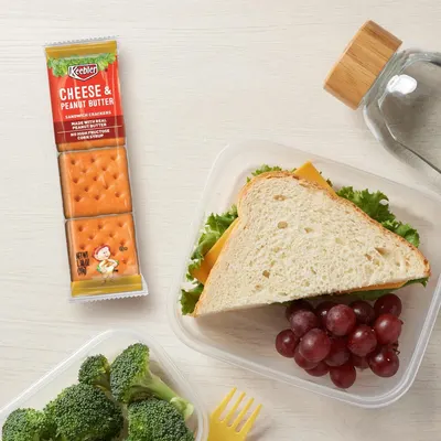Shows the product in a real-world lunch context to help shoppers visualize how the crackers fit into everyday meal occasions and portability.