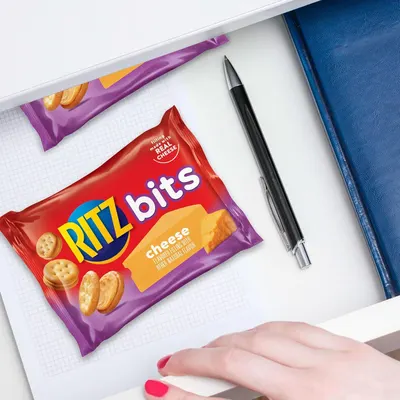 Demonstrates the product in a real-world context (desk/work/school setting) to help shoppers visualize using it as a convenient snack during daily activities.