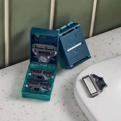 Shows the customer everything included in the purchase: a storage case with multiple razor cartridges and a razor handle, demonstrating the complete kit and value of the bundle.
