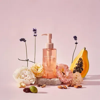 Creates an aspirational, natural beauty aesthetic by showcasing the cleansing oil surrounded by botanical ingredients like flowers, papaya, and nuts to communicate the product's natural formulation…