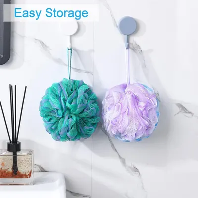 Demonstrates that the bath loofahs can be conveniently hung and stored using the attached loops, keeping the bathroom organized and allowing them to dry properly.