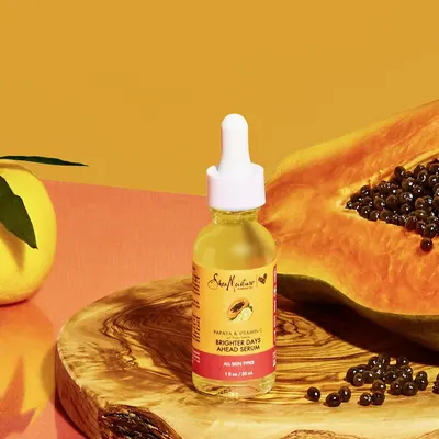 Showcases the product in a natural, visually appealing lifestyle setting with fresh papaya to reinforce the natural ingredient story and create an aspirational, organic brand aesthetic.
