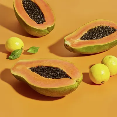 Communicates the product's natural, fresh ingredient profile through an aesthetically styled lifestyle photograph of papaya and citrus fruits, building trust and appealing to shoppers seeking…