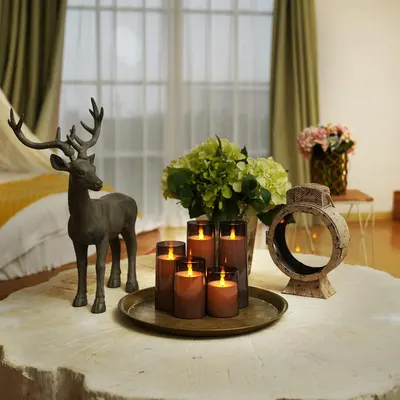 Showcases the candles in a styled, real-world home setting to help shoppers visualize how the product creates warmth and ambiance in their own living space.