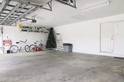 Demonstrates the product in a real-world garage setting, showing how it helps create a clean, organized space with overhead storage and floor space maximization.