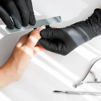 Demonstrates proper usage technique for the nail file product, showing shoppers how to hold and use the tool correctly during a manicure.