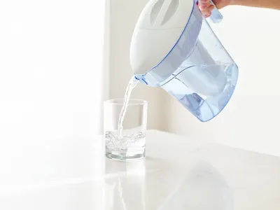 Demonstrates the water filter pitcher being used in a real-world home setting, showing the product in action to help shoppers visualize everyday use.