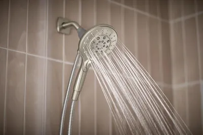 Demonstrates the product in a real bathroom setting with water flowing to show the showerhead in action and help shoppers visualize it in their own home.