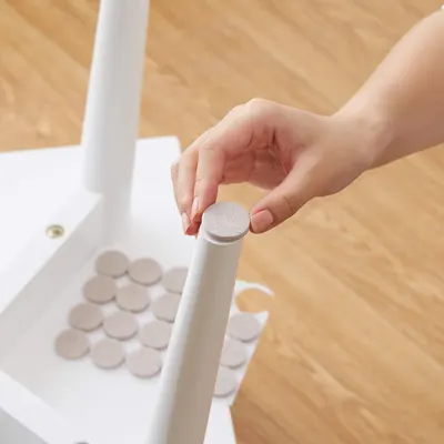 Demonstrates how to install protective felt pads onto furniture legs to prevent floor scratching and show ease of assembly.