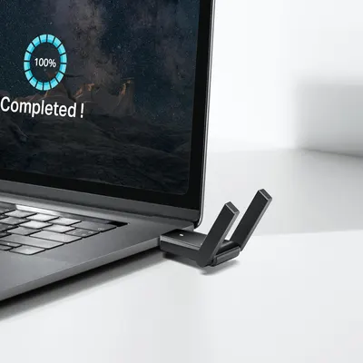 Demonstrates the product (WiFi adapter) in a real-world setting connected to a laptop, showing how it integrates seamlessly into everyday computing use.