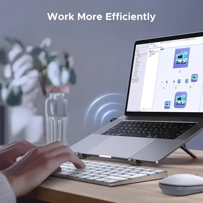 Demonstrates the product (laptop stand) in a real-world office/home workspace environment to help shoppers visualize how it fits into their daily work routine and enhances productivity.