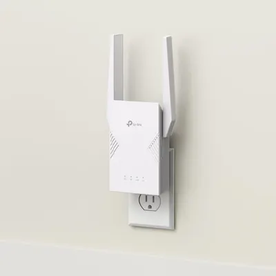 Shows the TP-Link WiFi extender plugged into a wall outlet in a real-world home setting, helping shoppers visualize how the product looks and fits in their space.