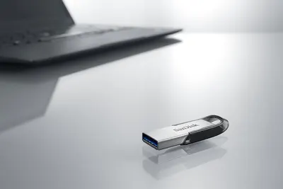 Demonstrates the product in a real-world office or workspace setting to help shoppers visualize the USB drive in their daily professional context.