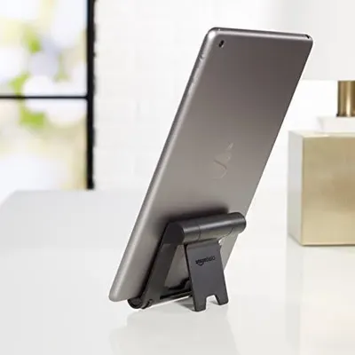 Demonstrates the product (tablet stand) in a real-world home or office setting to help shoppers visualize how it would look and function in their own space.