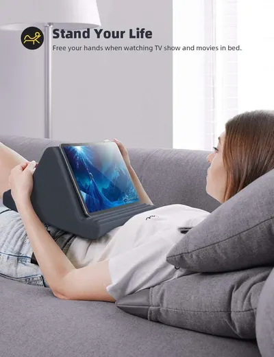 Demonstrates how the tablet pillow stand allows comfortable, hands-free viewing while lying down, freeing the user's hands and providing ergonomic support.