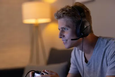 Shows the product being used in a real-world gaming environment to help shoppers visualize themselves using the headset at home.