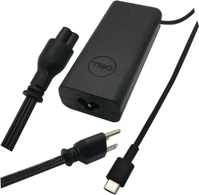 Shows all components included with the purchase: the Dell-branded power adapter, power cable, and USB-C charging cable, reassuring shoppers they receive everything needed to charge their device.