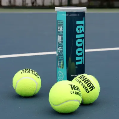 Shows the Teloon Championship tennis balls with their packaging in a clean, lifestyle tennis court setting to help shoppers see the product clearly and understand what they're purchasing.