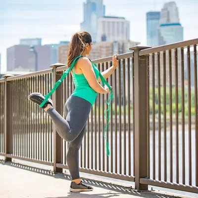 Demonstrates the product (resistance band) in a real-world fitness context to help shoppers visualize using it during outdoor workouts and stretching routines.