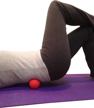 Demonstrates how to use the massage ball for targeted muscle relief, showing proper positioning under the glutes/hip area to reassure shoppers about correct usage technique.