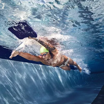 Shows the product (swim goggles and swim cap) in real-world use during swimming, helping shoppers visualize the product in action.