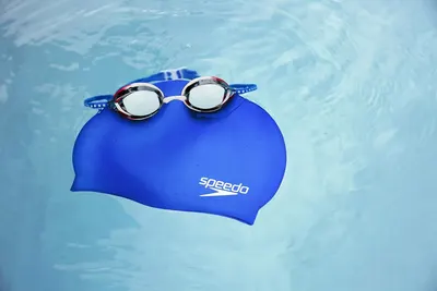 Displays the Speedo swim cap and goggles together in a clean, catalog-style presentation to show the product clearly without distractions.