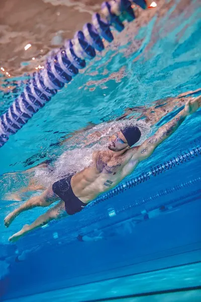 Shows the product being used in a real swimming pool environment to help shoppers visualize the product in authentic athletic use.