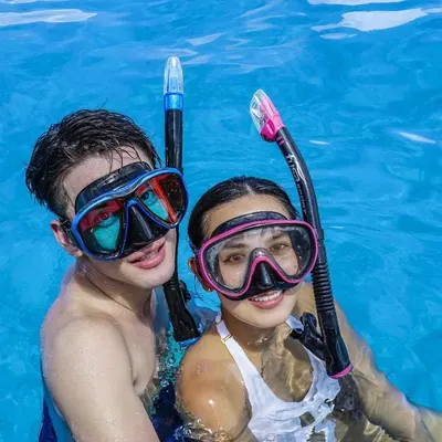 Demonstrates the product in a real-world recreational setting to help shoppers visualize themselves using the snorkel gear during pool or water activities.