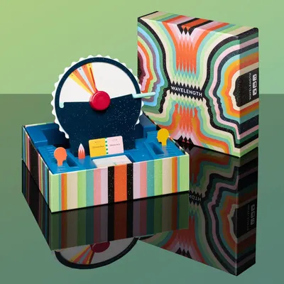 Shows all the components included in the Wavelength game box, including the dial mechanism, card holders, and game pieces, to help shoppers understand what they receive with their purchase.