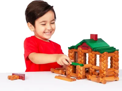 Demonstrates the product in use by showing a happy child engaged with the Lincoln Logs building set, helping shoppers visualize the play experience and emotional engagement the toy provides.