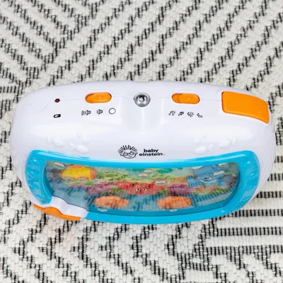 Displays the Baby Einstein toy clearly on a neutral background to show the product design, buttons, and underwater scene display without distractions.