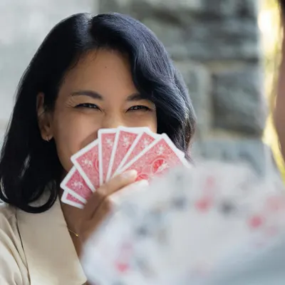 Shows the product (playing cards) being used in a natural, real-life setting to help shoppers visualize the product in their own lives and social activities.