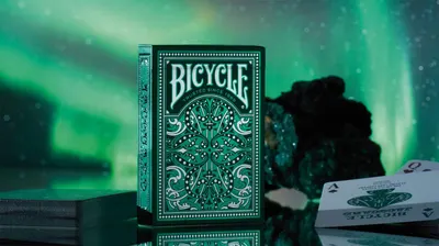 Showcases the Bicycle playing card deck in an atmospheric, lifestyle setting to emphasize its premium aesthetic and appeal to collectors or card enthusiasts.