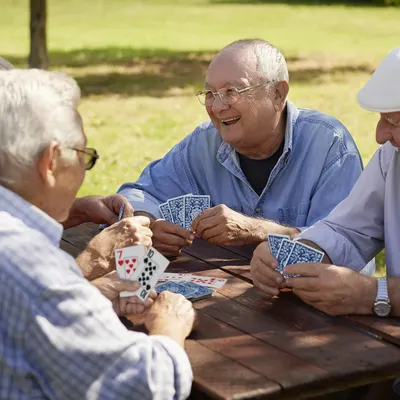 Shows the product (playing cards) being used in a real-world social setting to help shoppers visualize the product in their own lives and understand its use case for leisure and social connection.