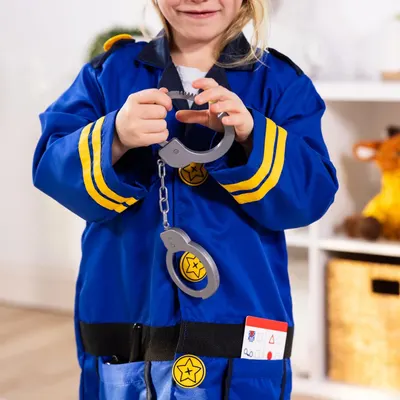 Shows the child wearing the complete police officer costume set with included accessories like handcuffs, badge, and ID card to demonstrate what comes in the package and how it looks when worn.