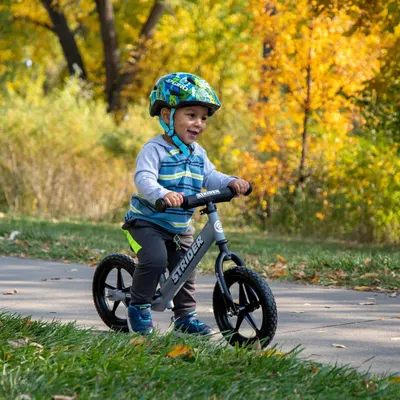 Demonstrates the product in a real-world outdoor setting with a child enjoying the balance bike, creating an emotional connection and showing the product's practical use in everyday life.