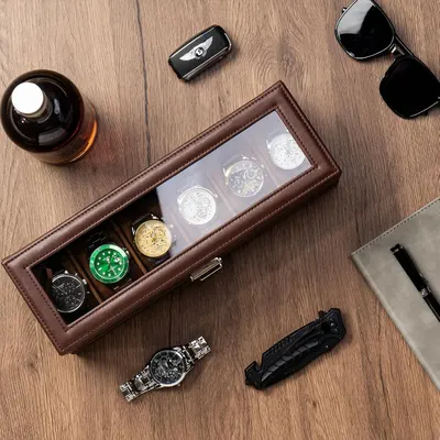 Showcases the watch storage case in an aspirational lifestyle setting with complementary luxury accessories to communicate sophistication and appeal to style-conscious shoppers.