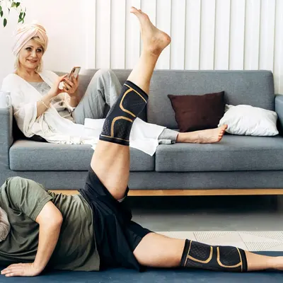 Demonstrates the product being worn comfortably in a real-world home environment, showing that the knee and leg support sleeves fit naturally into everyday relaxation and lifestyle activities.